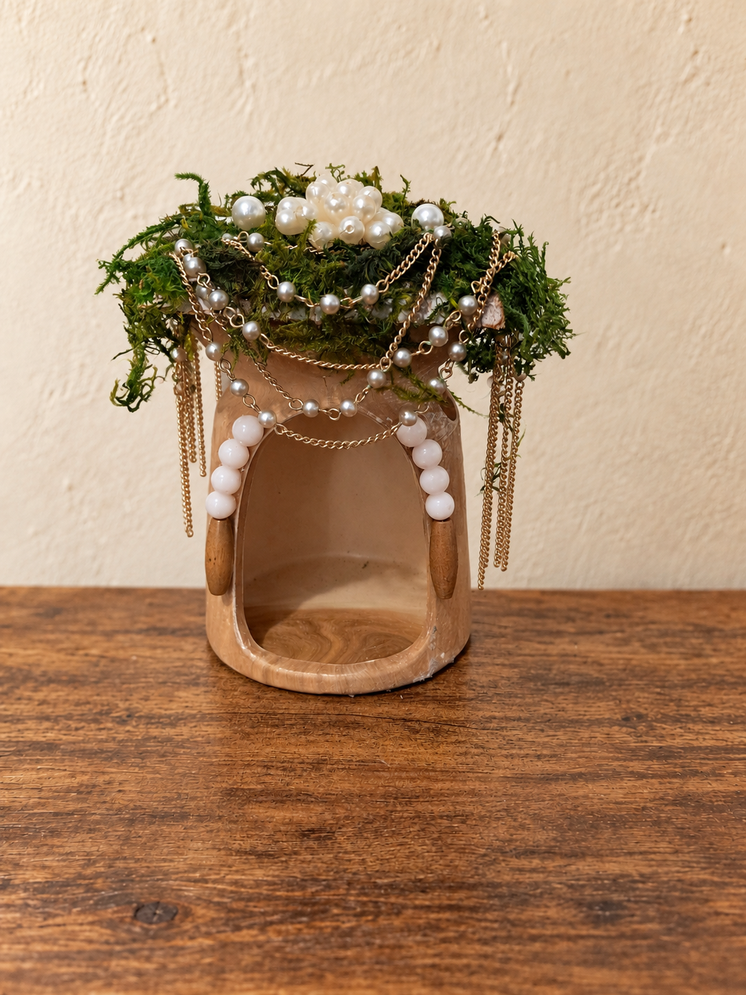 A thrifted tea-light warmer transformed into a moss-roofed fairy house with pearl and gold jewelry