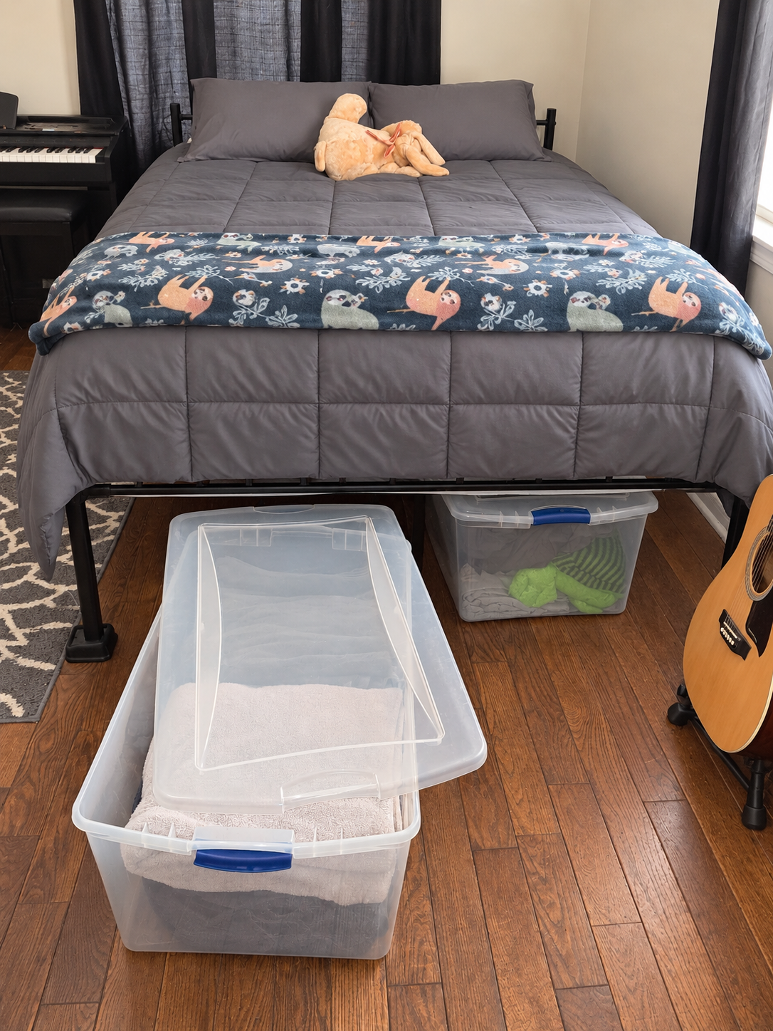 Clear storage bins being arranged beneath a bed raised just enough for easy access