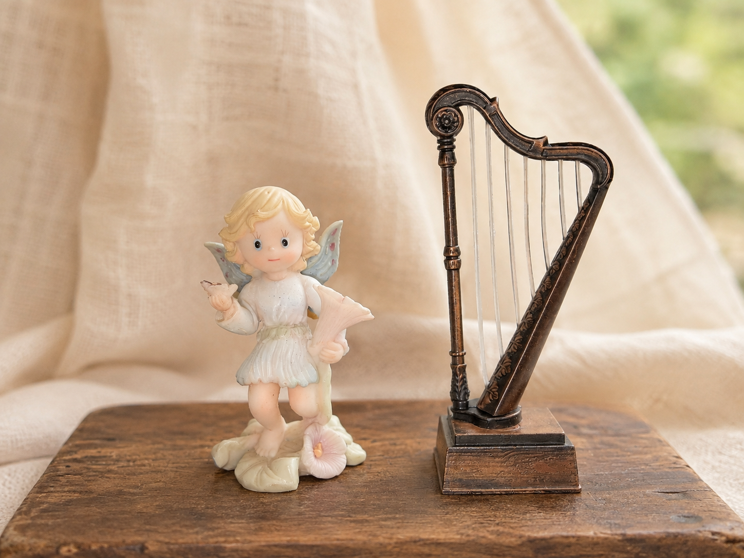 A thrifted fairy figurine beside a harp-shaped pencil sharpener