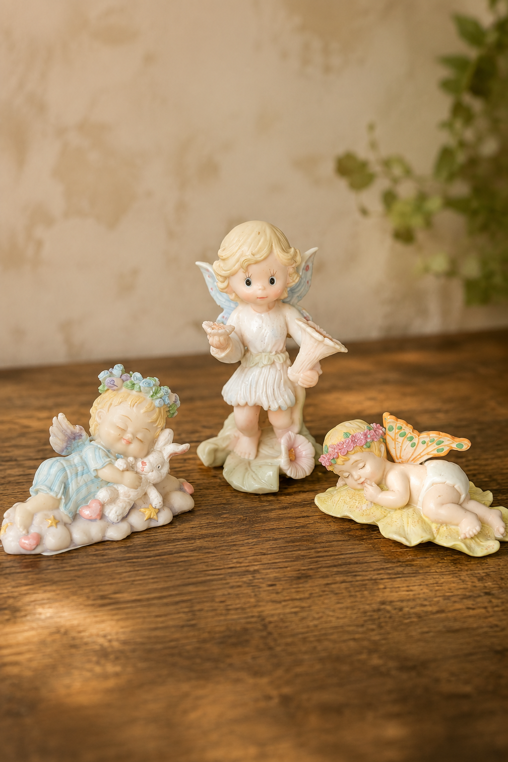 Three detailed thrifted fairy figurines arranged together